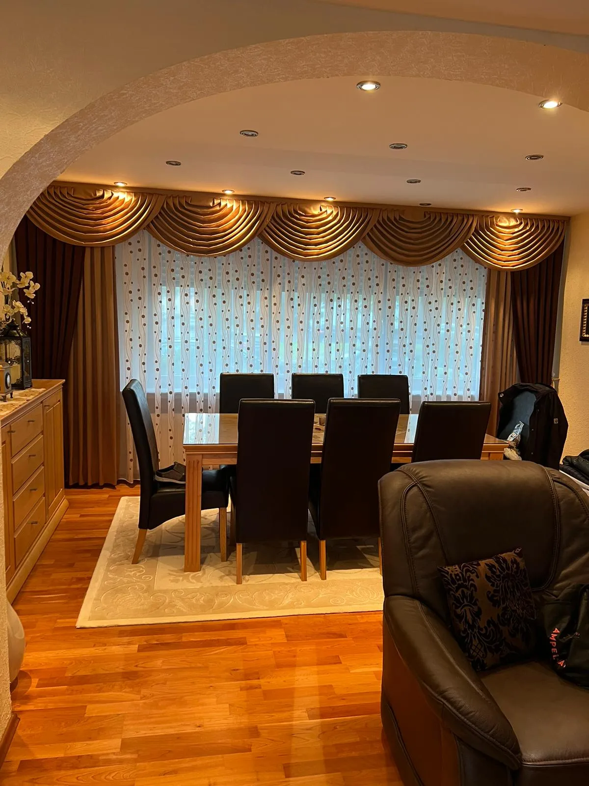 Esszimmer mit Querbehang, Dekoschals und Store in Gold- und Brauntönen